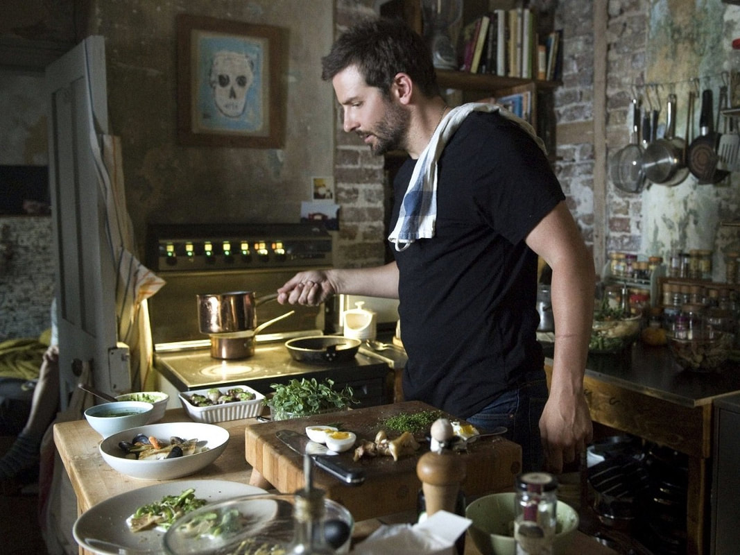 Bradley Cooper as Adam Jones cooking with eggs in a domestic kitchen