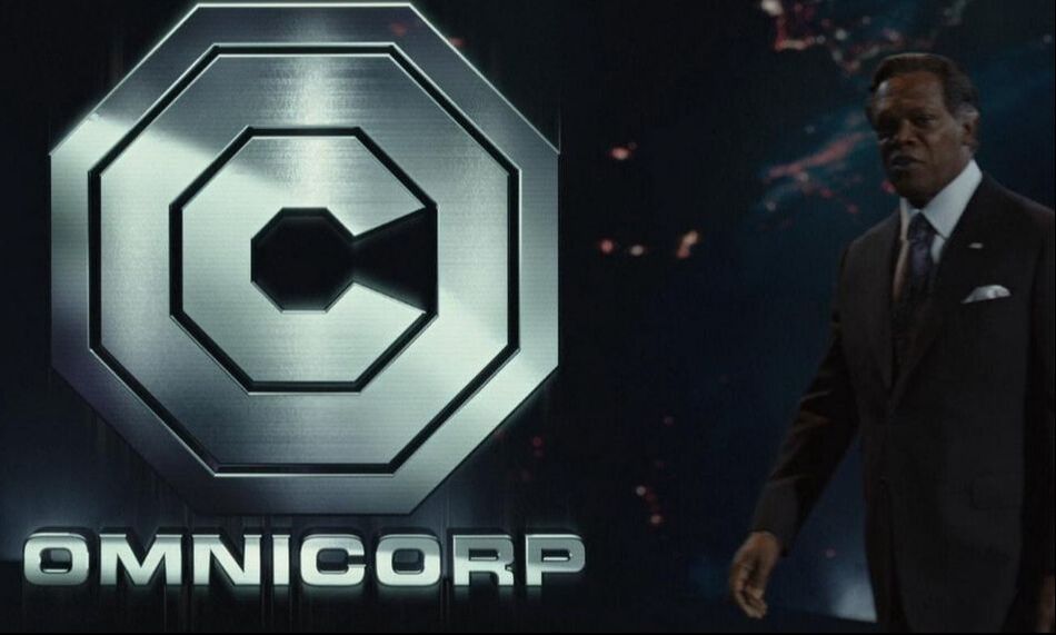 Samuel L Jackson wearing a suit standing next to the logo for fictional corporation Omnicorp