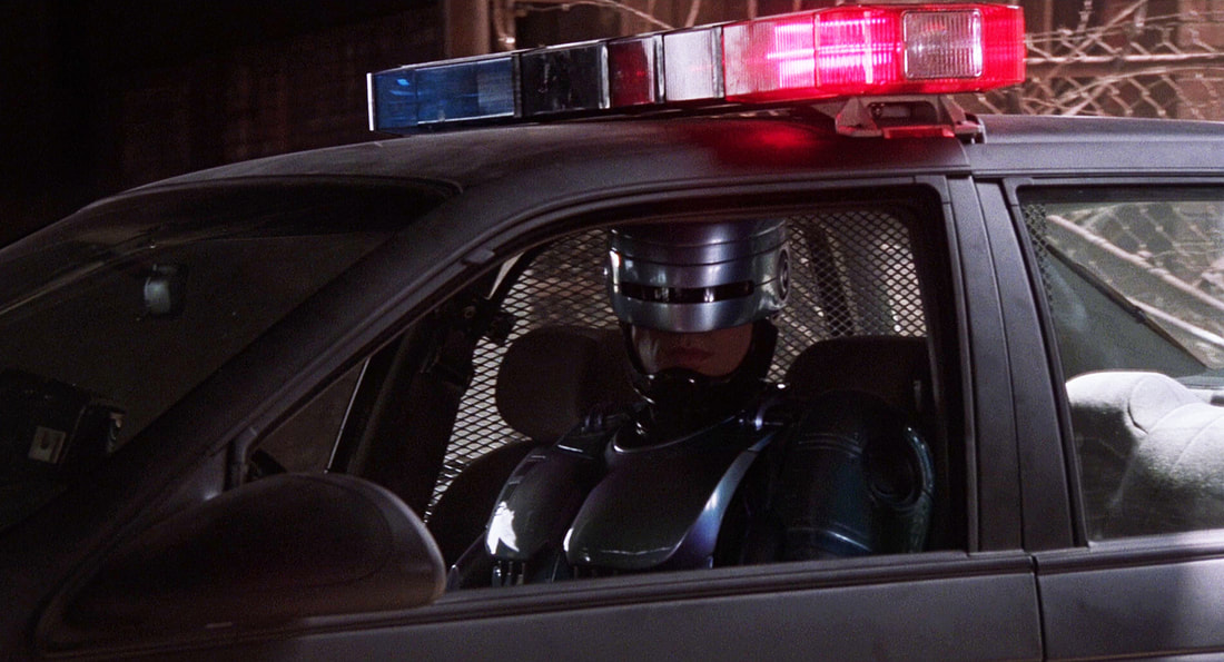 Robocop glaring out of the side window as he drives by in a darkened Ford Taurus